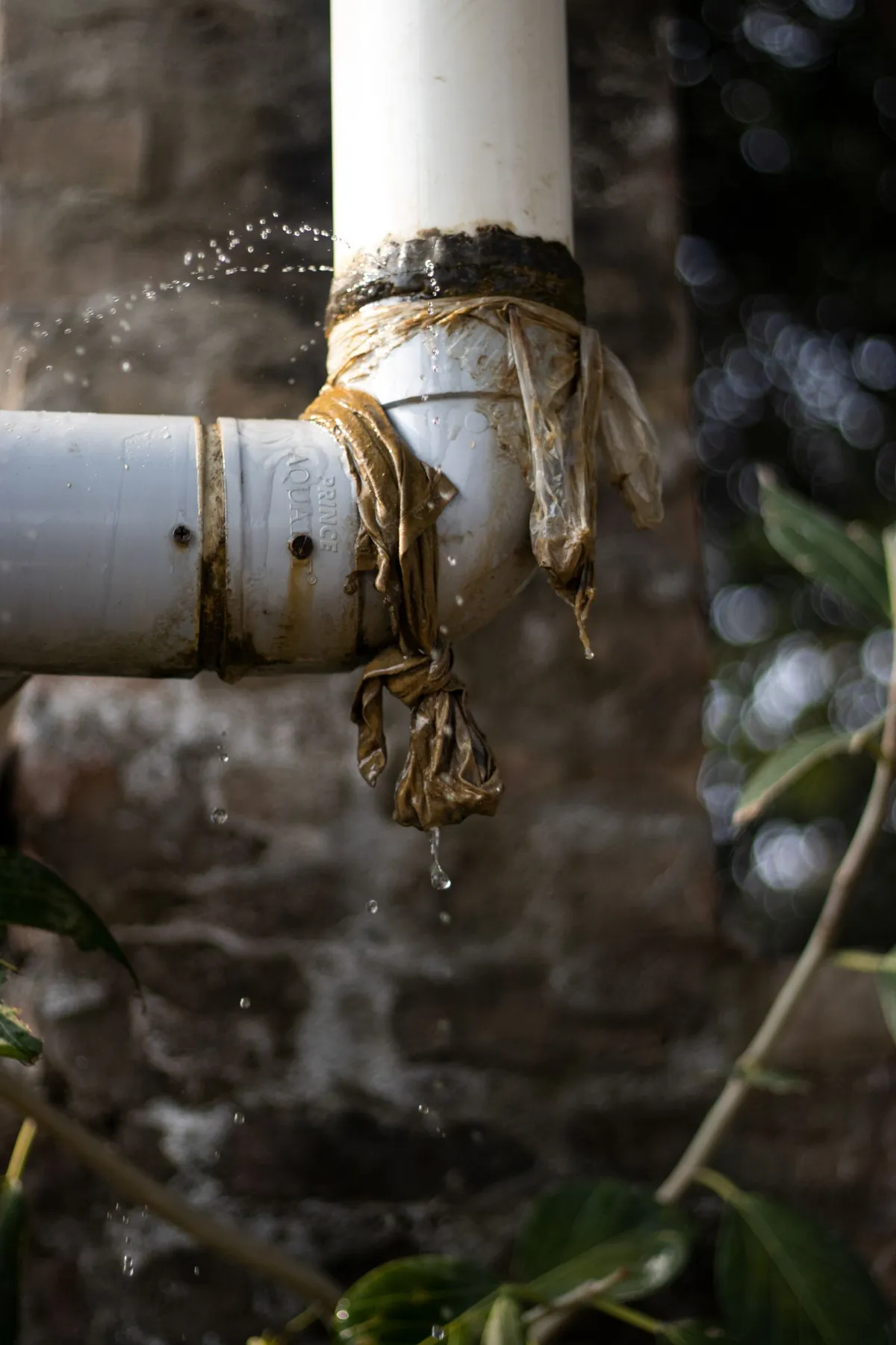 Burst copper pipe spraying water inside a home wall cavity