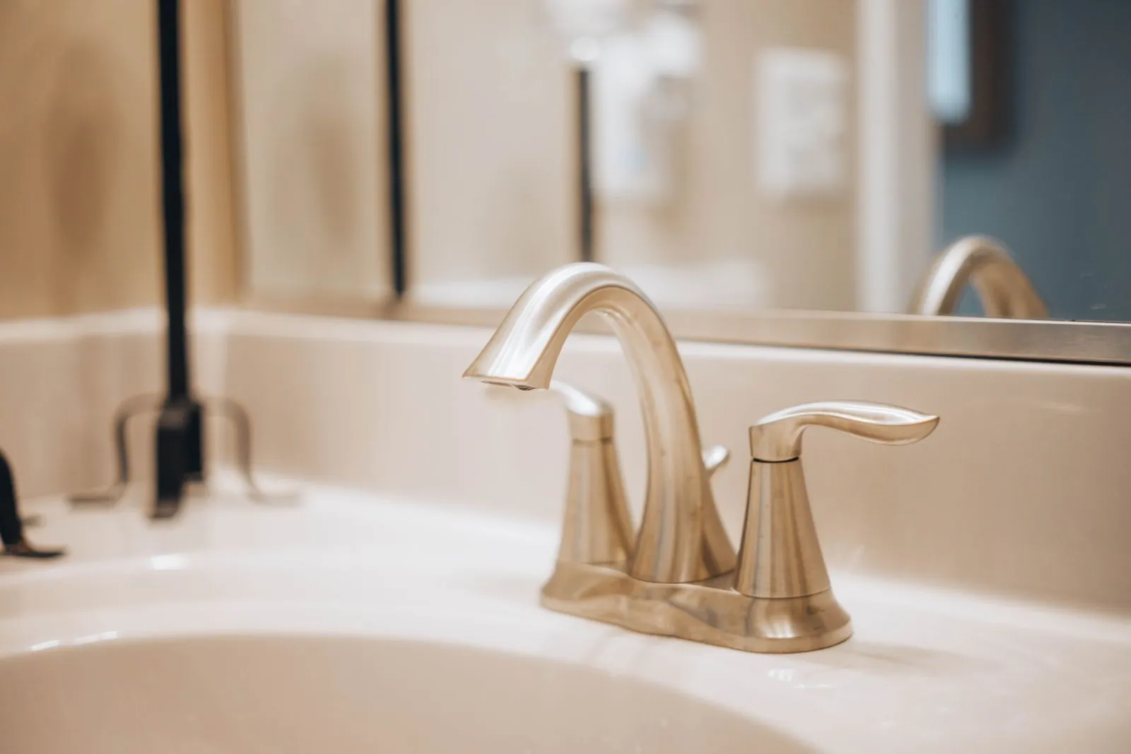 Plumber installing a modern bathroom faucet